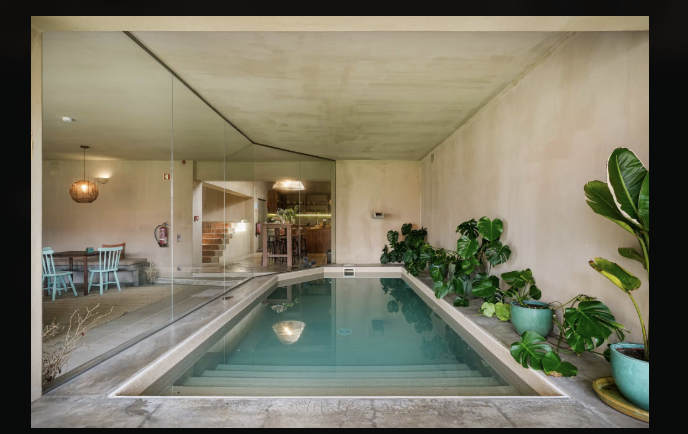 La piscina interna della villa, con la sala da pranzo oltre il vetro